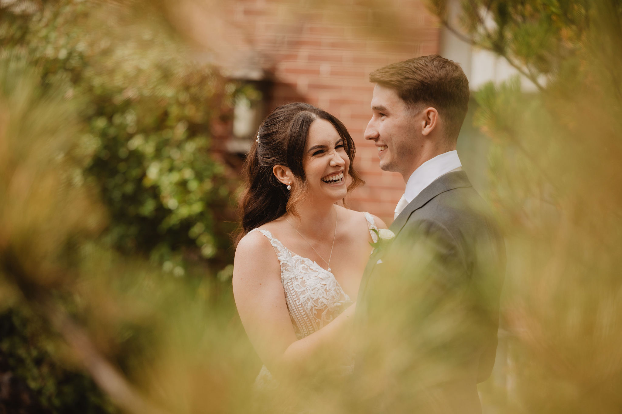 Brittney and Trevor framed through soft greenery