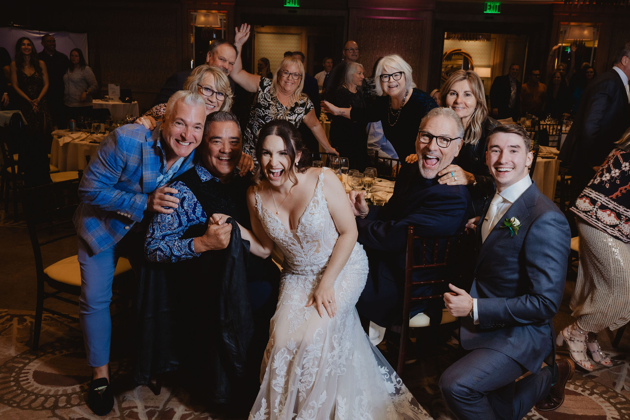 Brittney and Trevor laughing with wedding guests at a table